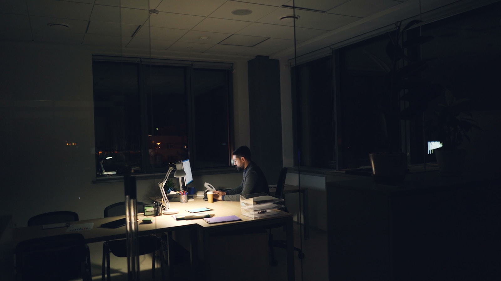 Man working late at a dimly lit office desk.